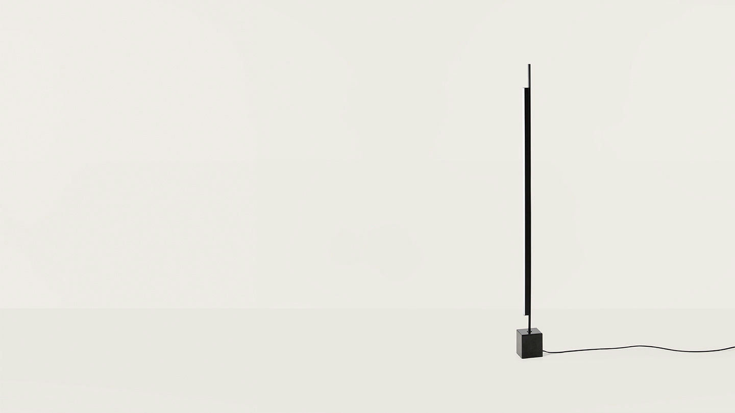 La lámpara de pie Coln presenta un diseño elegante con un poste negro delgado y una base cuadrada, que encarna el diseño minimalista sobre un fondo simple y claro. Un cable de alimentación se extiende elegantemente desde la base, resaltando la iluminación moderna en su máxima expresión.