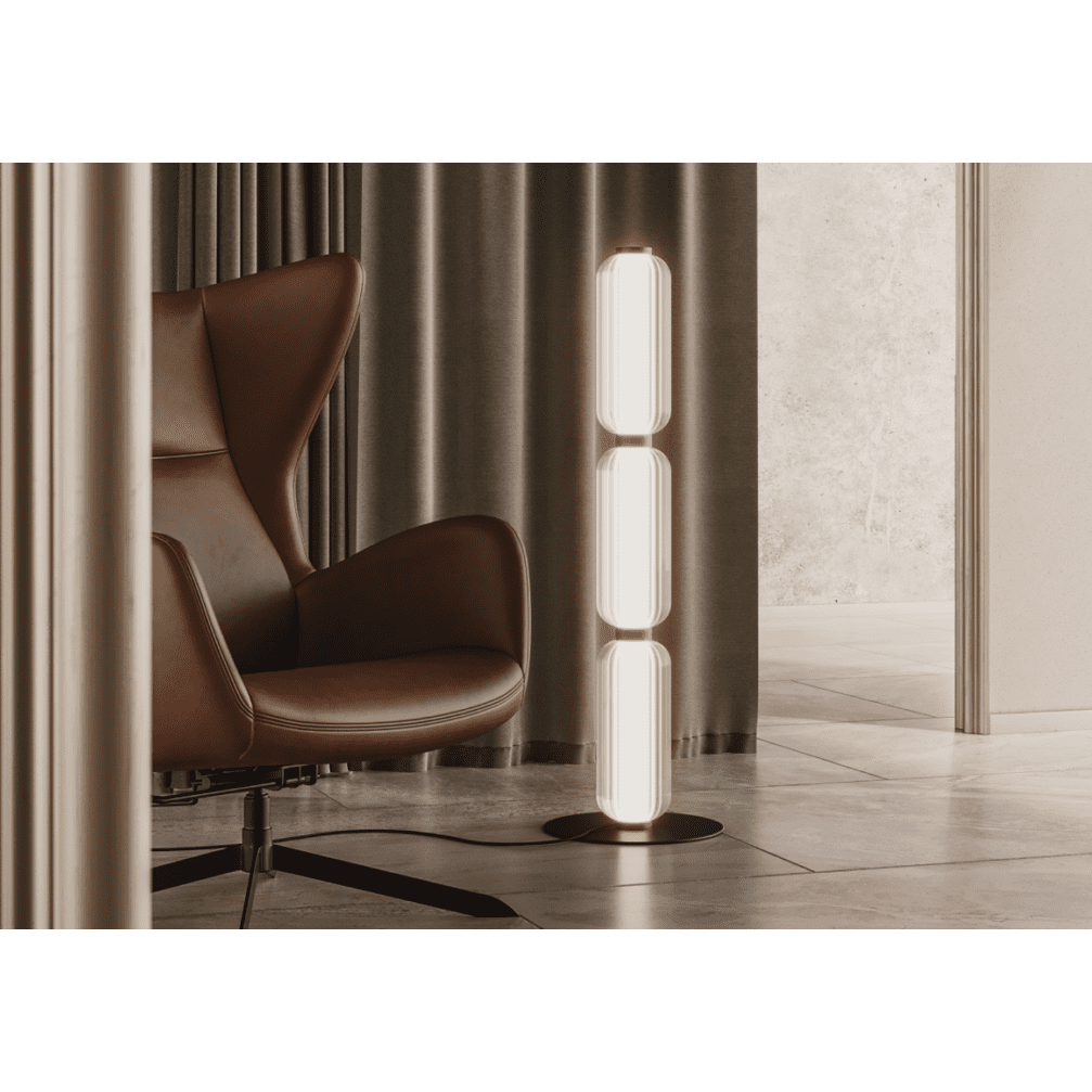 Un espacio de estar moderno exhibe un sillón de cuero marrón y la Lámpara de pie Elma para una iluminación difusa, contrastada con cortinas oscuras y paredes de colores neutros para un diseño sofisticado.