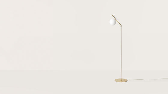 Una lámpara de pie minimalista con un delgado soporte dorado y una única bombilla LED, colocada sobre un fondo blanco liso. Lámpara de pie Endo.