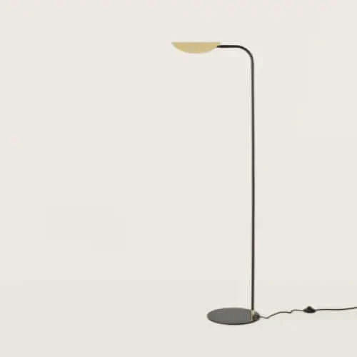 La Lámpara de pie Ficus presenta un diseño minimalista con un soporte de metal negro curvado, una base circular y una pantalla de media esfera orientada hacia arriba, que incorpora el diseño contemporáneo sobre un fondo liso.