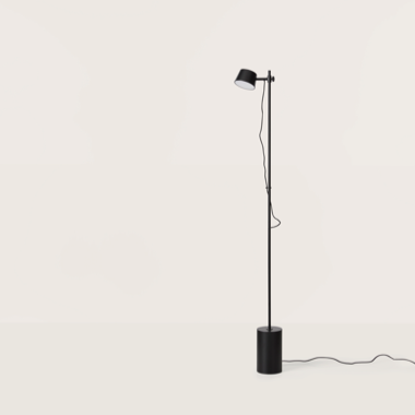 La Lámpara de pie Nera, con una base cilíndrica minimalista y una pantalla ajustable, se encuentra sobre una superficie blanca con un cable que se extiende desde la base, mostrando su elegante diseño moderno.