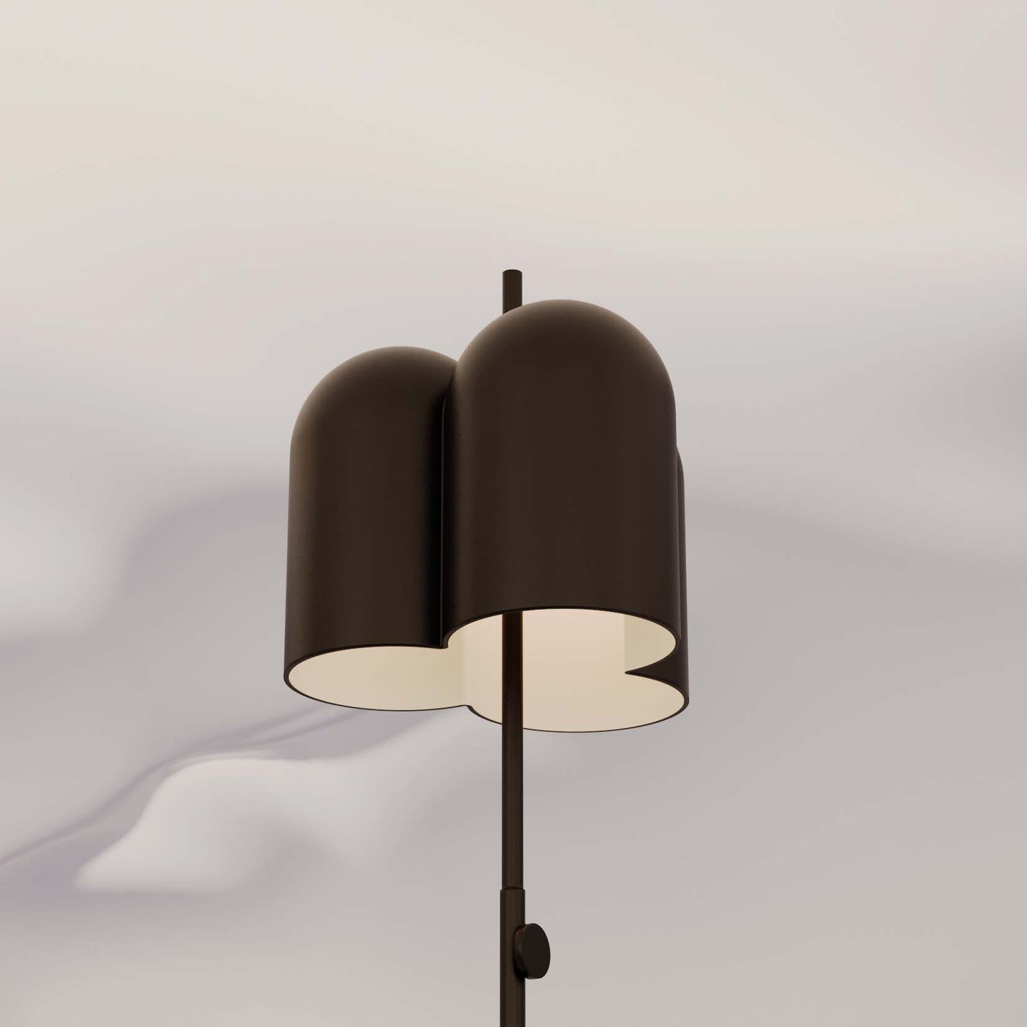 Una moderna Lámpara de pie Oket con doble pantalla marrón y diseño contemporáneo, que proyecta sombras suaves sobre un fondo gris claro.