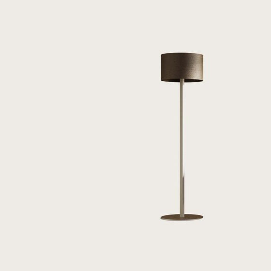 Lámpara de pie moderna, Lámpara de pie Rems, con un esbelto soporte de metal y una pantalla circular oscura, que presenta una iluminación sofisticada, aislada sobre un fondo claro.