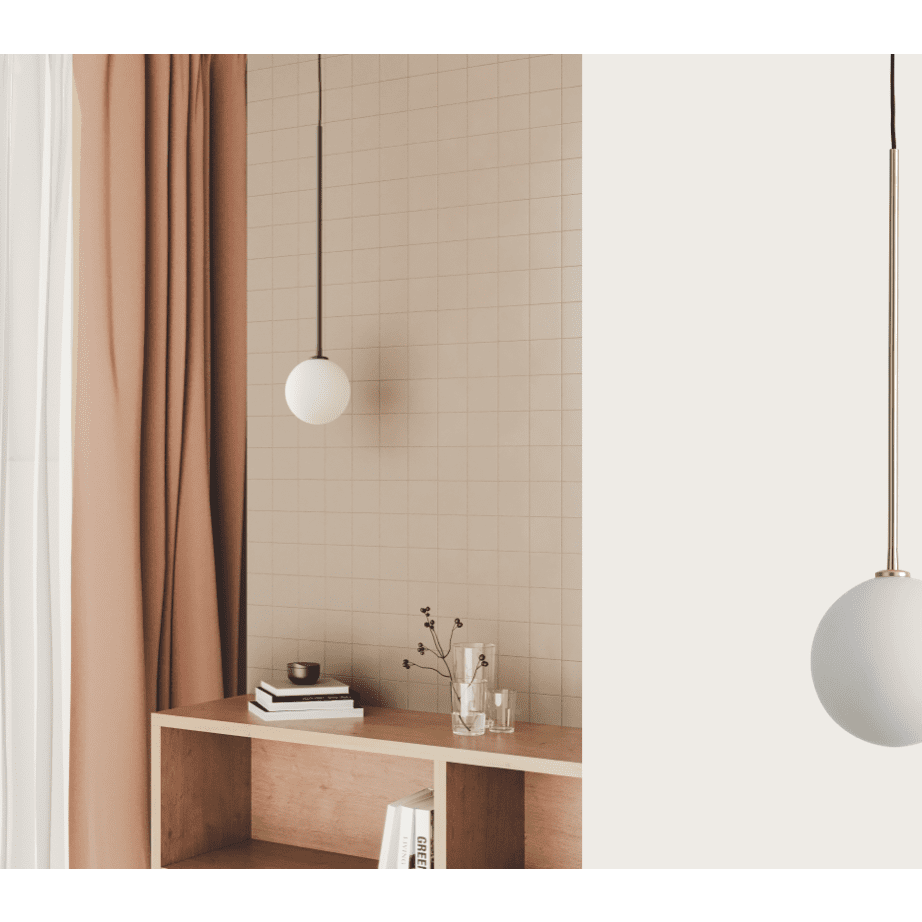 Una habitación minimalista muestra la lámpara de techo Ball, que proporciona iluminación difusa. Las cortinas beige cubren con elegancia una mesa pequeña con libros, una vela y un jarrón. Los diseños de paredes con azulejos realzan la elegancia de la habitación.