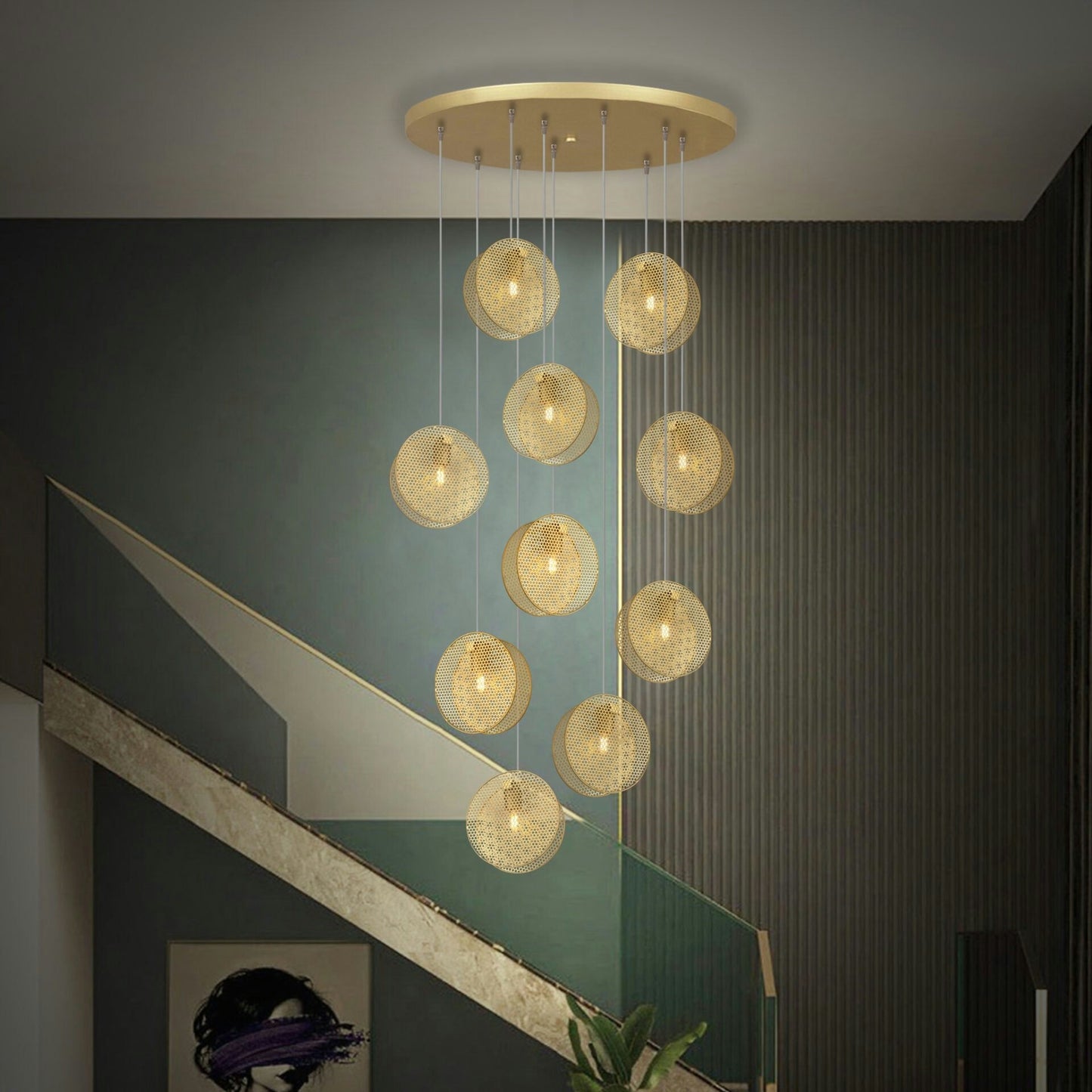 La Lámpara de techo Colgante Moderna Dorada 3224-10C-3, con múltiples luces esféricas brillantes, cuelga en una habitación tenue, destacando una pared verde texturizada y una escalera, ejemplificando el diseño moderno y minimalista.