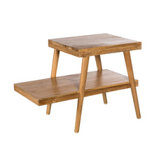  La mesita de noche en madera teca Fili es una mesa auxiliar de madera con dos niveles, patas en ángulo y acabado natural. Ofrece un diseño moderno y minimalista y una construcción duradera en madera de teca para un estilo contemporáneo.