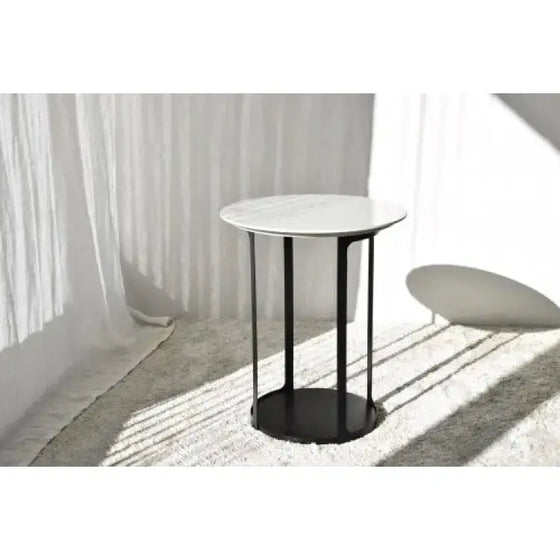 Una mesa redonda contemporánea con base negra y tapa de mármol, elegantemente diseñada para ser compacta, llamada Mesa Auxiliar N.30 Blanco y Negro - Urbicus.