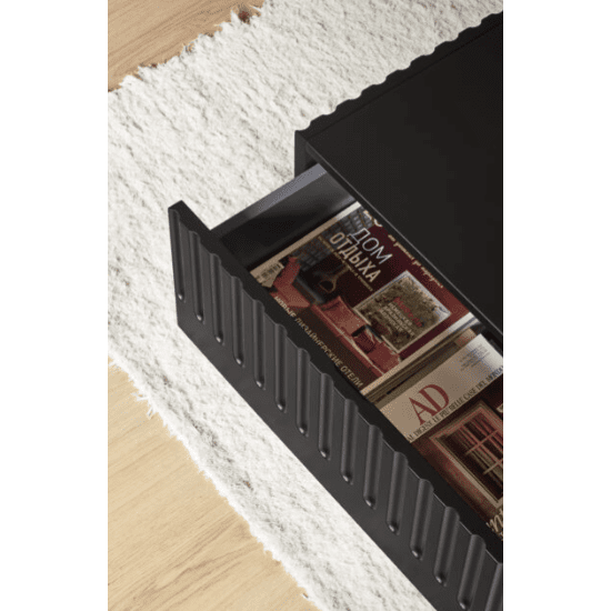 Mesa de Centro Doric apilada en un cajón de mesa de centro moderna y negra con una superficie acanalada, sobre una alfombra texturizada blanca, que muestra tendencias en decoración.