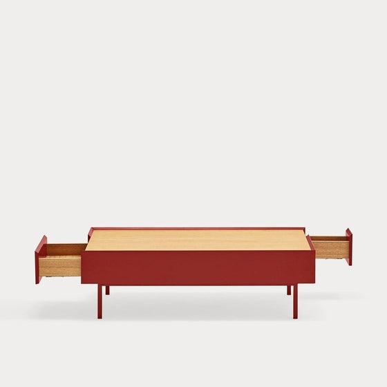 Una mesa de centro Bailey roja minimalista con tapa rectangular y extensiones cilíndricas a cada lado, sobre un fondo blanco liso.