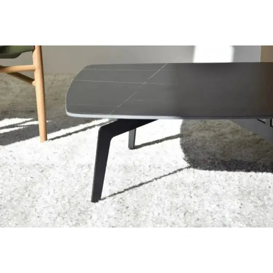 A Mesa de Centro N.00, Piedra Sinterizada Negra y Vetas Ocres hecha de Piedra Sinterizada Negra en una habitación con una silla.