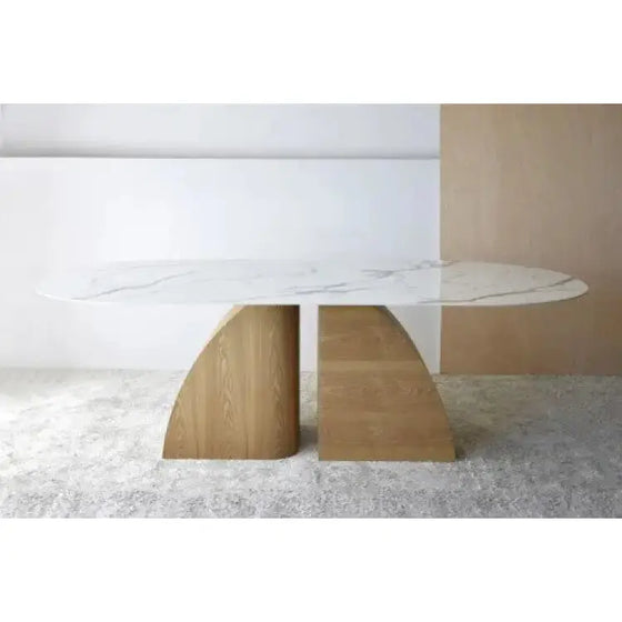 Una mesa de comedor de mármol blanco con patas de madera, con el nombre del producto "Mesa de Comedor. Natural, Blanco, Ocre - Bahía" para un acabado de fresno natural y una tapa duradera de Piedra sinterizada.