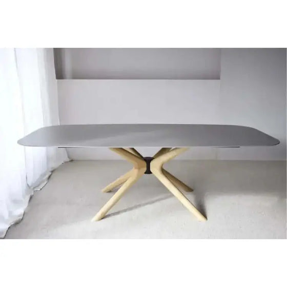 Una Mesa de Comedor Piedra Cerámico Gris Fresno con patas de madera.