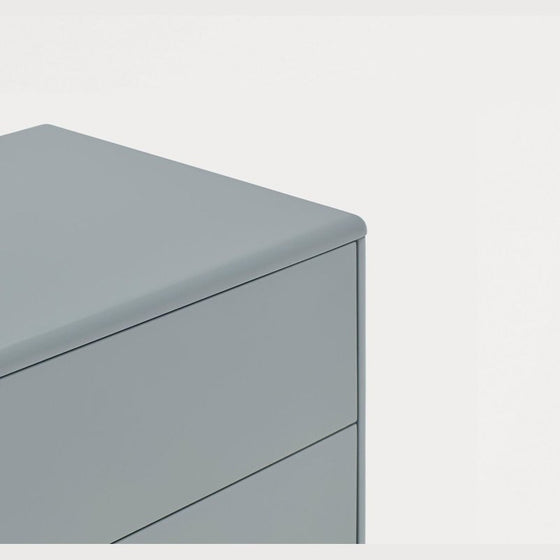 Una imagen minimalista que presenta la esquina de una Mesita Corvo 2C con un diseño moderno sobre un fondo blanco liso.