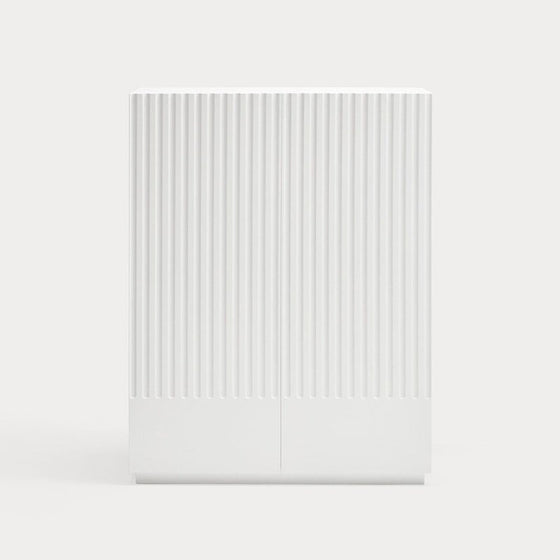 Una escultura minimalista de Mueble Auxiliar Doric 2P2C con ranuras verticales sobre un fondo blanco liso contemporáneo.