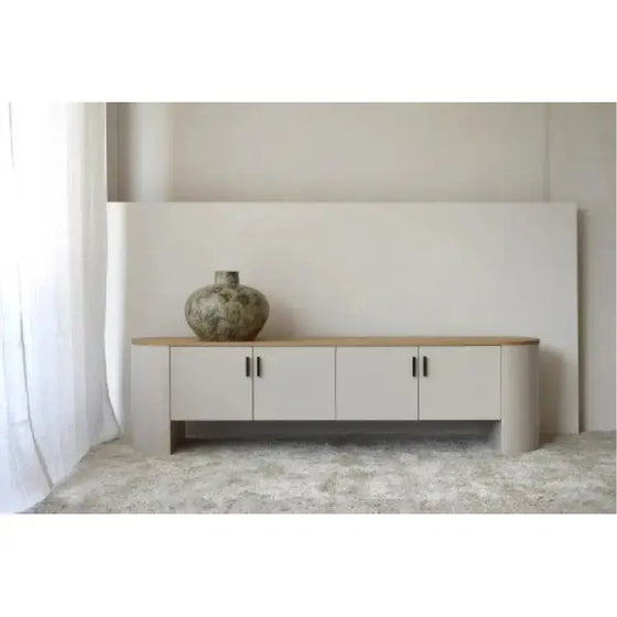 A Mueble TV Gris Arena y Roble - Té en una habitación con un jarrón.