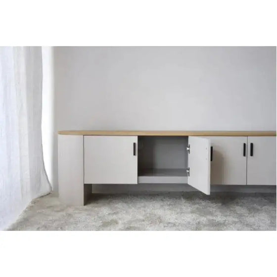 Un Mueble TV contemporáneo Gris Arena y Roble - Té en una habitación blanca.