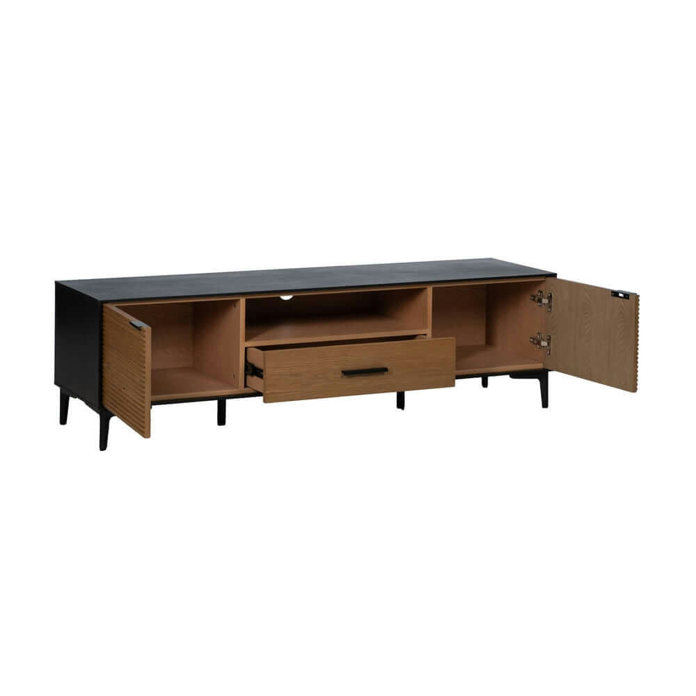 El Mueble de TV Novomix Negro-Natural DM-Madera es una consola de madera minimalista y elegante hecha de fresno, con una cubierta negra, un cajón central y estantes. Las puertas laterales abiertas del gabinete revelan un espacio de almacenamiento adicional ideal para su configuración de TV.