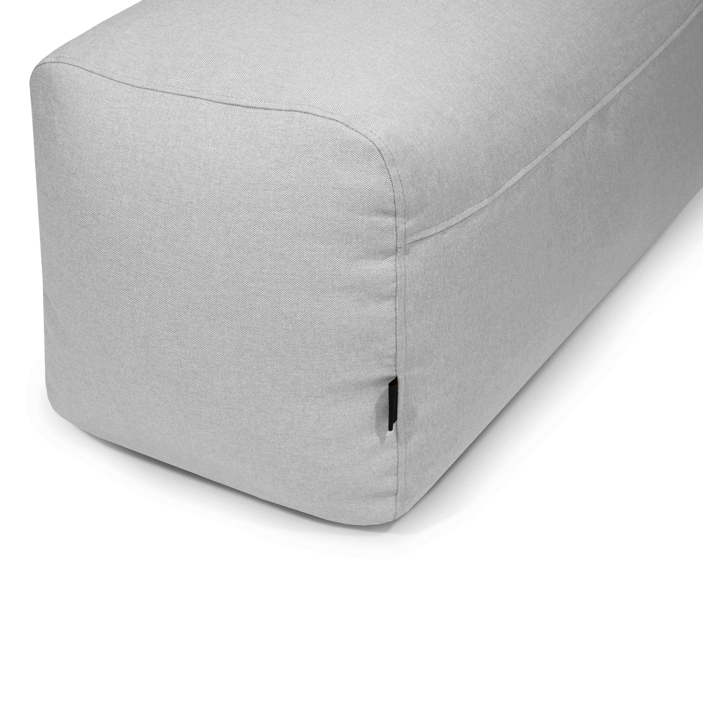 El PLUS 100 NORDIC es un puf rectangular de tela lavable de color gris claro (100×60×45 cm), compacto y ligero con bordes redondeados, ideal como asiento adicional en el dormitorio o el salón.