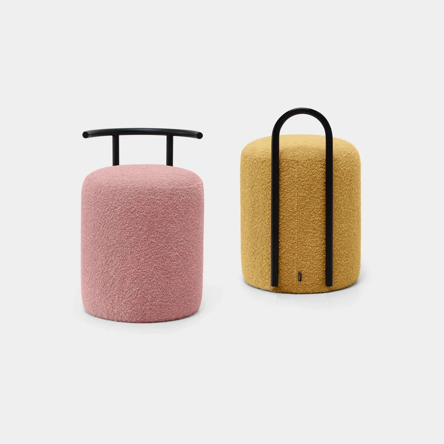 Dos taburetes Puff Redondo Tapizado Horn C con tela texturizada: uno rosa con asa de barra horizontal y el otro amarillo con asa de arco vertical. Ambas manijas son negras, lo que agrega un toque de estilo contemporáneo y garantiza durabilidad.