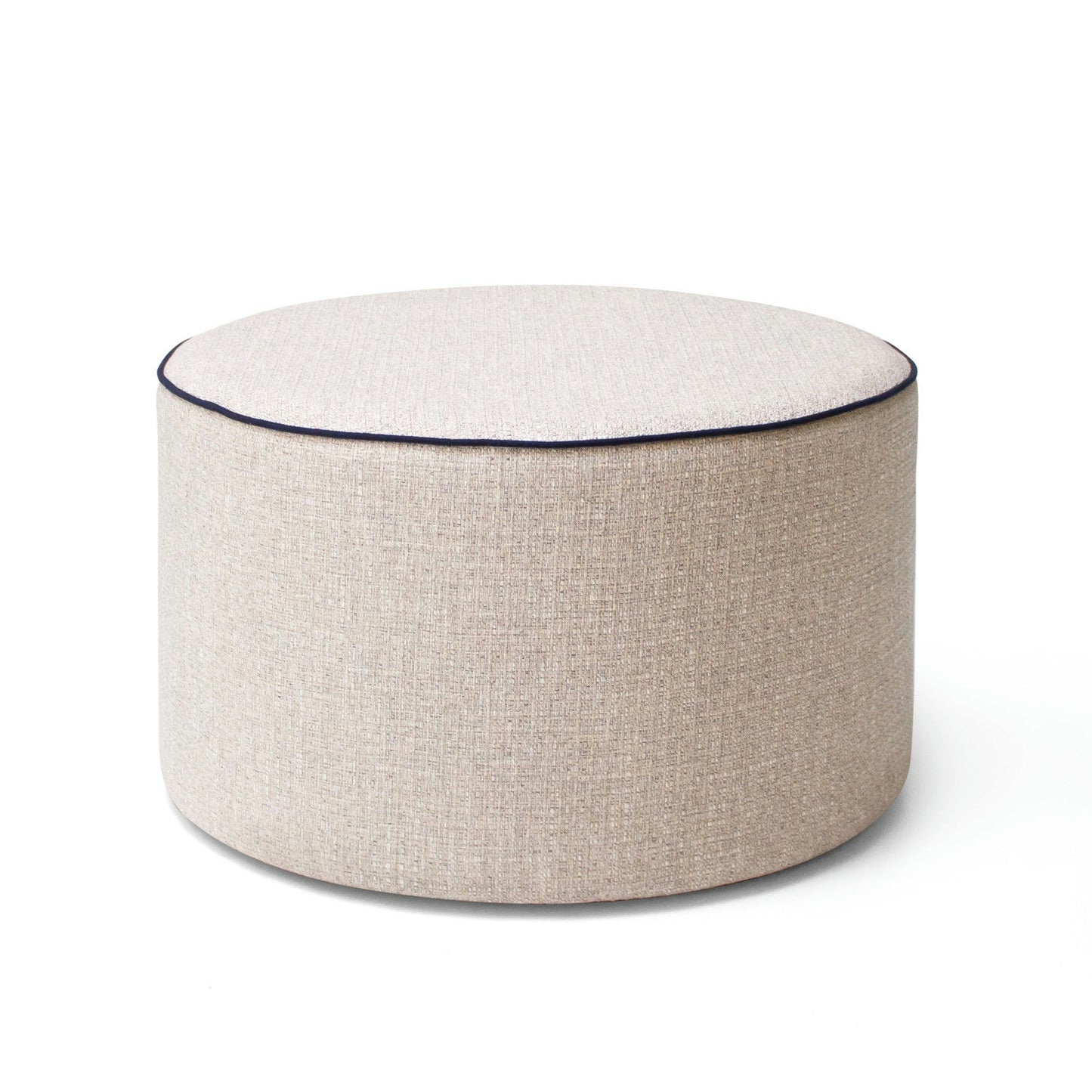 El puf redondo tapizado Puff Redondo es una pieza redonda de color beige claro con un diseño minimalista y ribete oscuro en la parte superior. Ideal para decoración contemporánea y mobiliario contract.