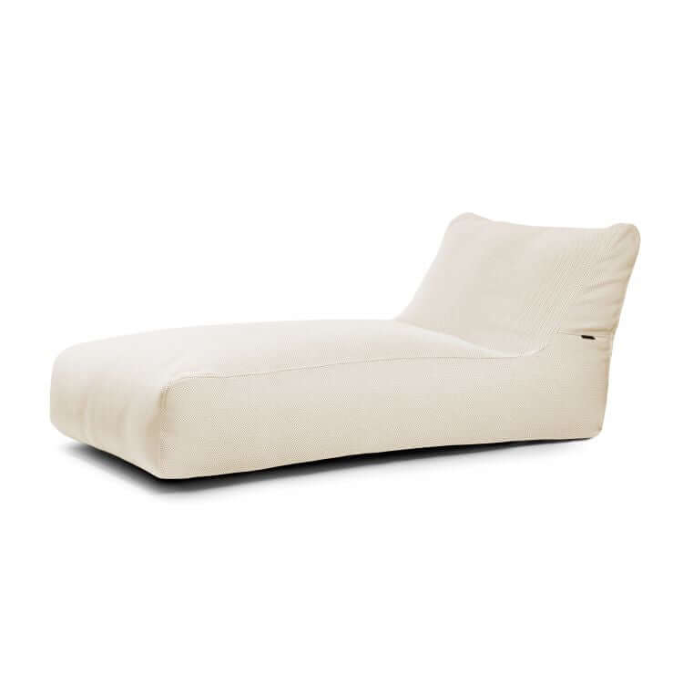La tumbona Bean bag 90 Canaria es una moderna tumbona de exterior beige sin brazos, de perfil bajo y respaldo ligeramente inclinado, que se muestra sobre un fondo blanco.