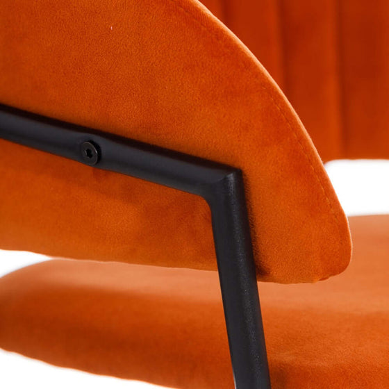 Vista cercana del respaldo y asiento de una Silla Teja Tejido-Metal Salón 53 x 58 x 73 cm de terciopelo naranja con estructura de metal negro, mostrando su lujosa textura de poliéster.