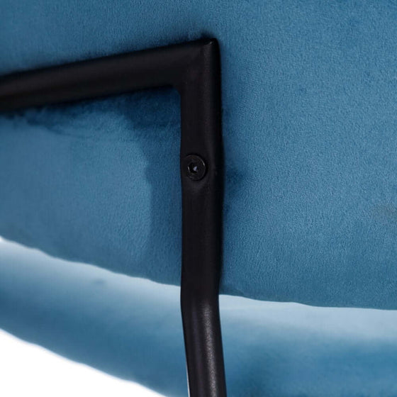 Primer plano de una silla de comedor tapizada en azul, esquina Velvetine Azul Tejido-Metal Salón con una pata de metal negro.