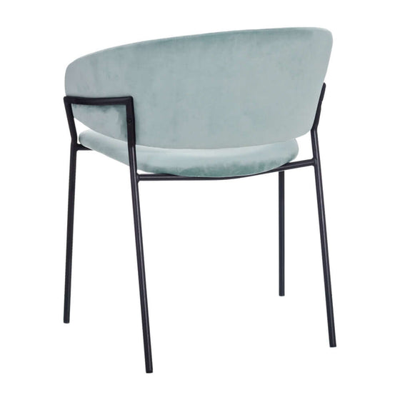 Silla de comedor Velvetine Azul con diseño contemporáneo, marco negro y asiento acolchado de terciopelo azul pálido sobre un fondo blanco.