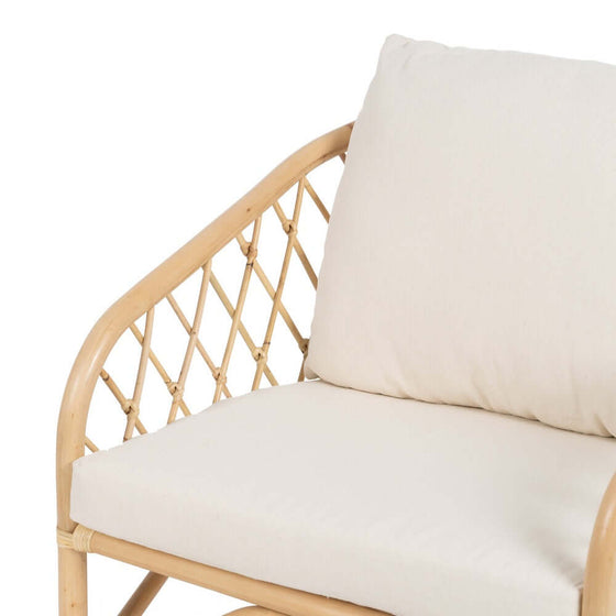 Un cojín beige sobre un sillón Sillón BreezyNook Natural-Ratán marrón claro sobre un fondo blanco.