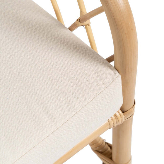 Descripción: Primer plano de un asiento acolchado color beige con estructura de silla de madera, mostrando un Sillón BreezyNook Natural-Ratán de diseño minimalista.