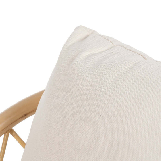 Primer plano de una almohada con textura beige sobre un Sillón BreezyNook Natural-Ratán con fondo blanco.