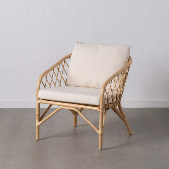 Un Sillón BreezyNook Natural-Ratán de diseño minimalista con cojines, contra un fondo sencillo.