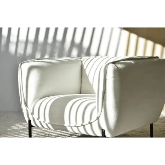 Descripción: Un Sillón Contemporáneo de color blanco con formas curvas, frente a una ventana.