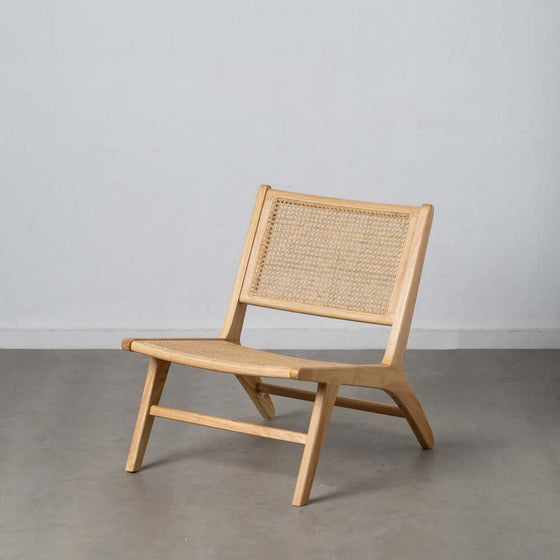 Sillón Natural-Ratán con un respaldo tejido contra un fondo gris.