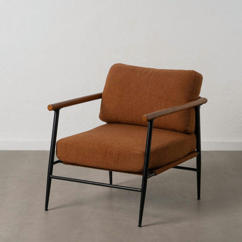 El Sillón de Metal con Cojines Rubberwood cuenta con apoyabrazos acolchados, detalles de madera y una elegante estructura de metal. Se asienta sobre un piso gris contra una pared blanca, lo que resalta su diseño contemporáneo.