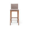 El Taburete Alto en Madera y Tapizado Max Vintage es un taburete alto de bar de madera con respaldo y asiento acolchados, tapizado en tela marrón texturizada, que muestra un estilo retro.