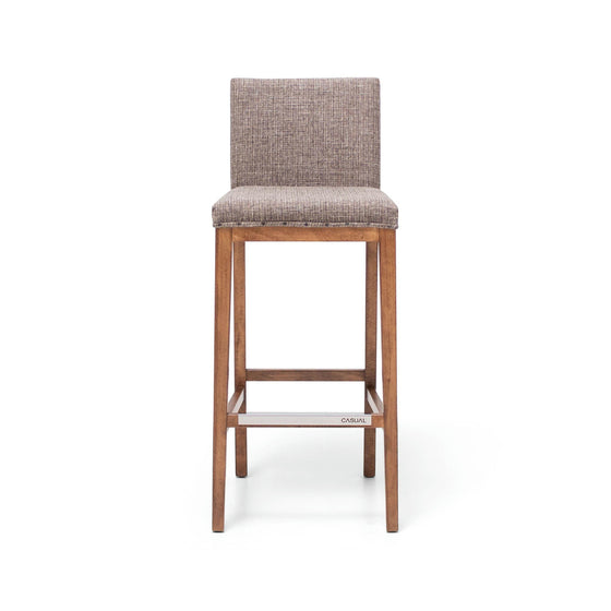 El Taburete Alto en Madera y Tapizado Max Vintage es un taburete alto de bar de madera con respaldo y asiento acolchados, tapizado en tela marrón texturizada, que muestra un estilo retro.