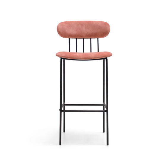 El Taburete Alto en Metal y Tapizado Miki, que presenta un marco negro con cuatro patas rectas y un reposapiés, cuenta con un respaldo y asiento tapizados de color rosa para mayor comodidad y estilo.