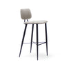El Taburete Alto en Metal y Tapizado Umai ofrece un diseño moderno con un asiento y respaldo acolchados en gris claro, complementados con elegantes patas de metal negro.