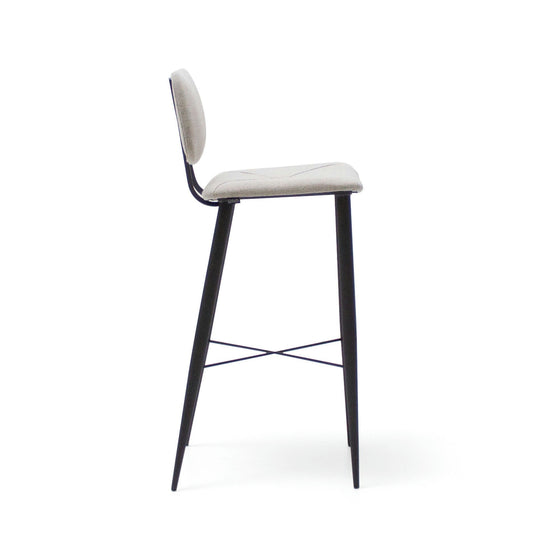 Vista lateral del Taburete Alto en Metal y Tapizado Umai que presenta un asiento y respaldo acolchados en color blanco, sostenido por una elegante estructura de metal negro con patas y reposapiés, mostrando su sofisticado diseño.