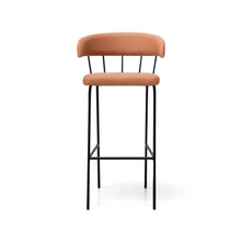  El taburete de bar Yasmina presenta un diseño moderno con un asiento y respaldo acolchados de color marrón claro, sostenidos por un elegante marco de metal negro.