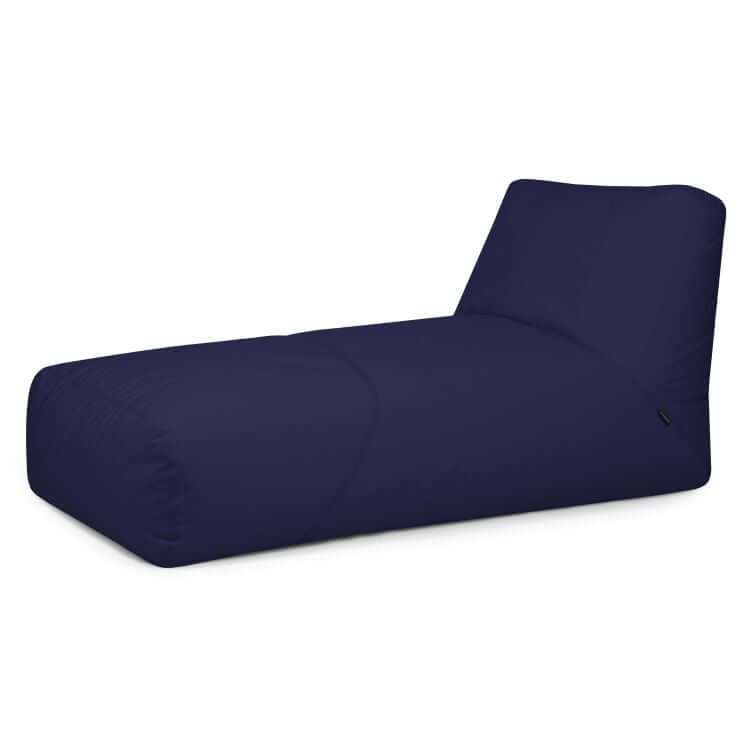 El Bean bag Tube 100 Daybed Colorin en azul oscuro presenta un respaldo ligeramente reclinado, perfecto como mueble de jardín para exteriores, y se muestra aislado sobre fondo blanco.