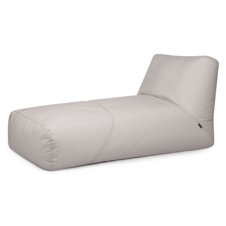 El Bean bag Tube 100 Daybed Colorin, diseñado para uso exterior, presenta un color beige claro, un perfil bajo moderno y un respaldo en ángulo, perfecto como sillón exterior. Se muestra aquí sobre un fondo blanco.