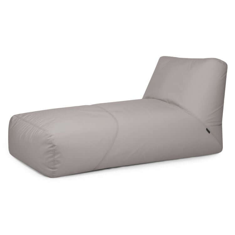 El Bean bag Tube 100 Daybed Colorin (uso exterior) es una chaise lounge gris claro con una suave funda de tela y respaldo reclinable, ideal como elegante sillón de exterior o para relajarse entre sus muebles de jardín.