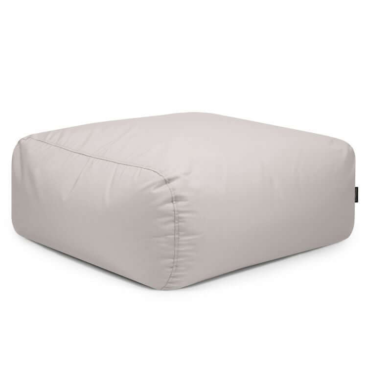 El Puf cuadrado de tejido resistente al sol 85×85×38 cm TUBO 80 COLORIN es un puf moderno y ergonómico, ideal como asiento exterior o acento interior, con tela suave y bordes redondeados en gris claro.