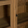 Primer plano de una Vitrina en Madera de Teca y Cristal Rico con puertas revestidas de vidrio, que presenta una llave decorativa de metal en la cerradura, que emana un aire de diseño contemporáneo.