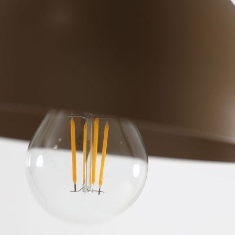 El primer plano de una bombilla LED con filamentos amarillos visibles, parcialmente cubierta por una pantalla marrón oscuro, encarna el sofisticado diseño de Aplique de pared en hierro negro y dorado Alston.