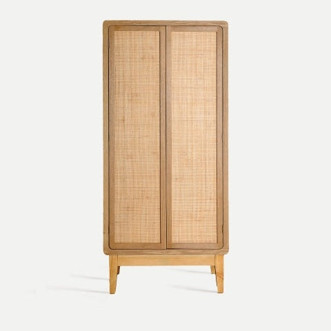El armario en madera de abeto Doazit, con dos puertas de tejido de ratán y cuatro patas cortas, brinda un amplio espacio de almacenamiento sobre un fondo blanco.