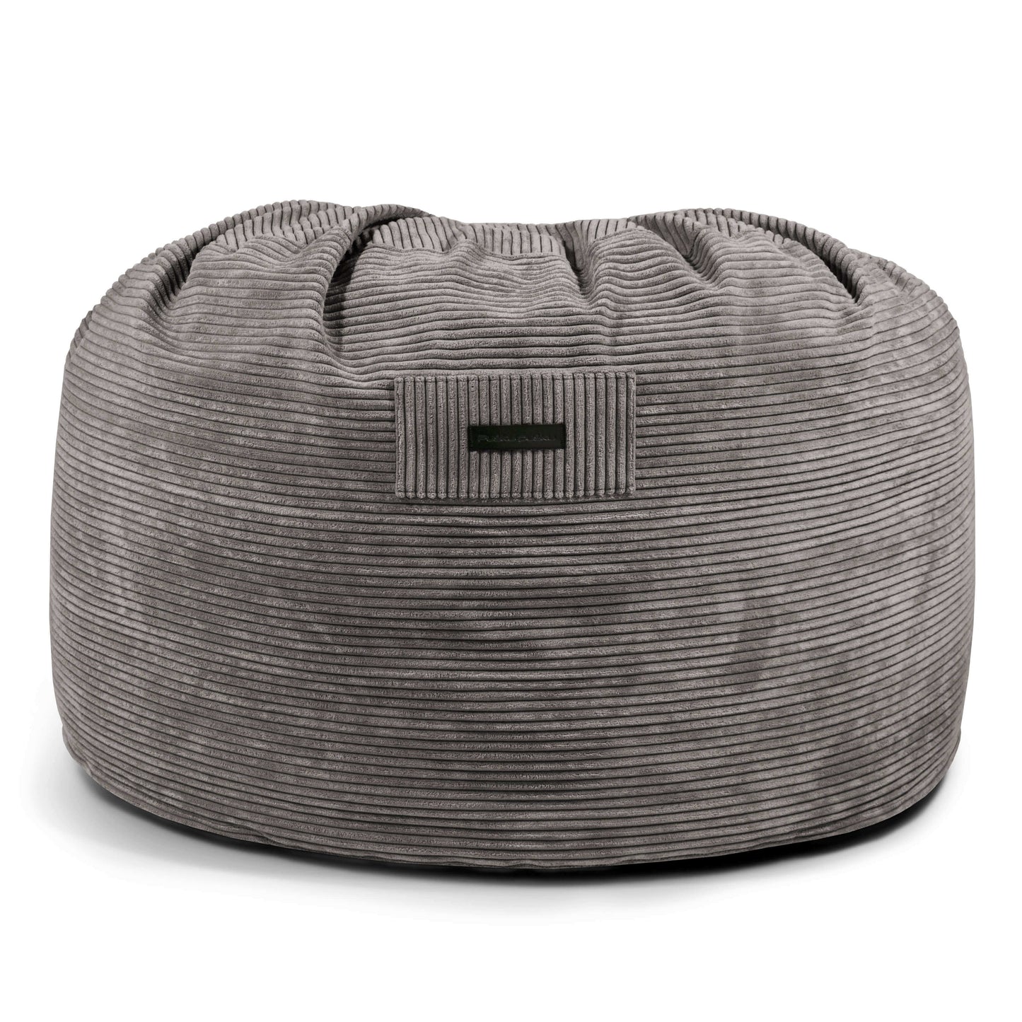 La Foam Bean Bag OM 110 Barcelona es una silla redonda de pana gris con una pequeña etiqueta lateral negra, diseñada como asiento ergonómico y mostrada sobre fondo blanco.