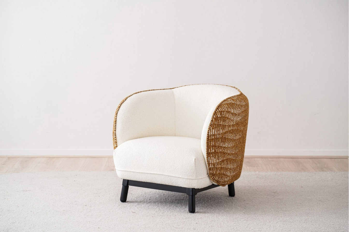 El sillón curvo tapizado en blanco bouclé y mostaza CURVA (85×84×77 cm) aporta un toque de diseño contemporáneo a cualquier espacio minimalista.